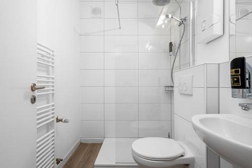 a white bathroom with a toilet and a sink at Apartment 5, direkt am Bahnhof in Aachen