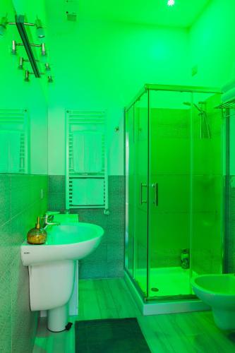 a green bathroom with a sink and a shower at San Nicolò 3 in Verona