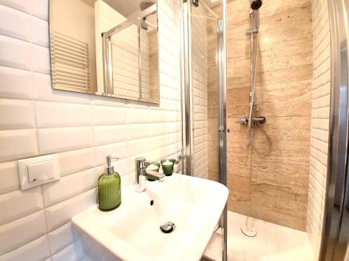 a bathroom with a sink and a shower at Rental Apartments Smolna in Warsaw