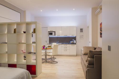 a kitchen and a living room with a couch and a table at San Nicolò 3 in Verona