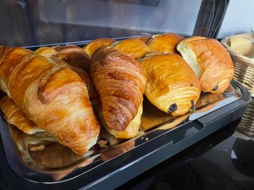 uma bandeja de croissants e pastelaria numa padaria em Logis Hôtel du Cirque Troyes centre historique em Troyes