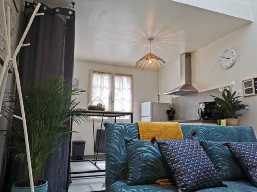 a living room with a blue couch and a kitchen at Les bords de Seine in Vernon