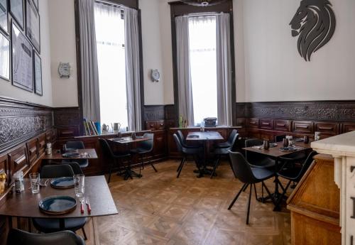 a restaurant with wooden tables and chairs and windows at Heirloom Hotels - The Mansion in Ghent
