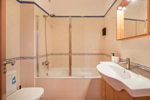 y baño con ducha, aseo y lavamanos. en Charming Apartment in Alfama with River View, en Lisboa