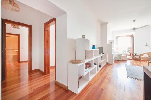 a living room with white cabinets and a hard wood floor at Charming Apartment in Alfama with River View in Lisbon