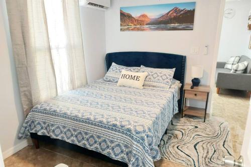 a bedroom with a bed with a blue comforter at The Torres' Loft West Tampa MidTown Raymond James Stadium in Tampa