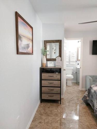 a bathroom with a dresser with a toilet and a mirror at The Torres' Loft West Tampa MidTown Raymond James Stadium in Tampa