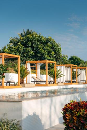a pool at a resort with chairs and a gazebo at Safira Blu Luxury Resort & Villas in Nungwi