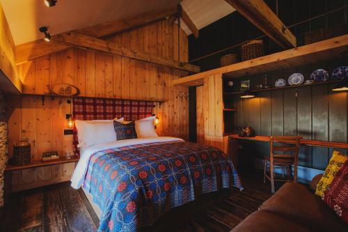 1 dormitorio con 1 cama en una habitación con paredes de madera en Albion Aberteifi, en Cardigan