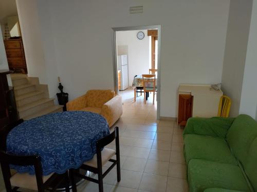 un soggiorno con divano verde e tavolo di La Casa al Centro a Rionero in Vulture