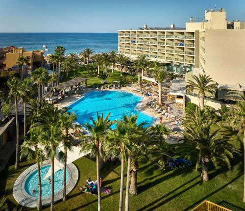 een luchtzicht op een resort met palmbomen en de oceaan bij Sirens Beach & Village in Malia