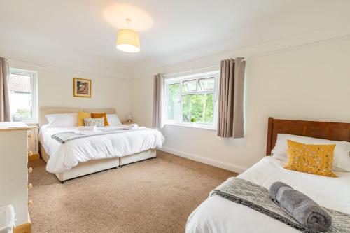 1 dormitorio con 2 camas y ventana en St Clements House - Norfolk Holiday Properties, en Norwich