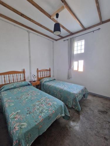 a bedroom with two beds and a window at Casa Rocio in Güimar