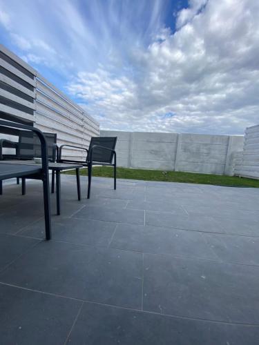 two benches sitting on a patio near a wall at Fly Studios in Tunari