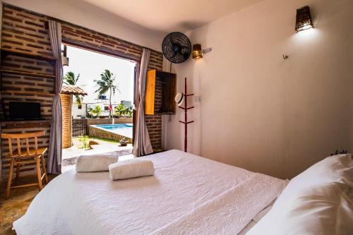 a bedroom with a bed and a large window at Pico dos Piratas in Itarema