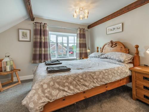 a bedroom with a large bed and a window at Lesta Cottage in Everingham