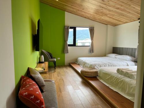 1 dormitorio verde con 2 camas y sofá en Chi Lan Liye Homestay en Chishang