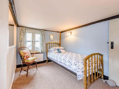 a bedroom with a bed and a chair in it at Sunny House By The Sea in Dymchurch