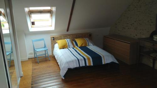une chambre avec un lit et une chaise bleue dans l'établissement Les Hortensias, à Plouha