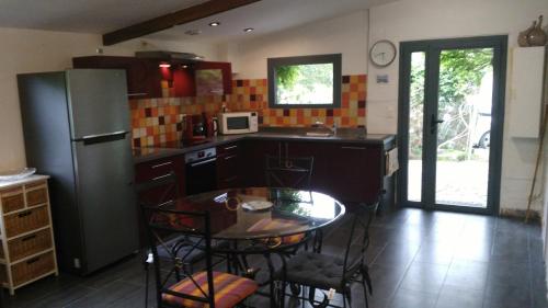 une cuisine avec une table et un réfrigérateur dans l'établissement Les Hortensias, à Plouha