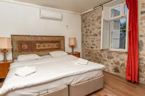 Un dormitorio con una cama grande y una ventana. en Iconic Stone Houses, en Izmir