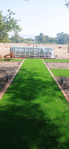 a grassy field with a building in the background at אחוזת המייסדים in Bet Hillel