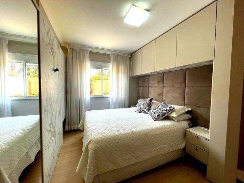 a bedroom with two beds and two windows at Apartamento Villa Nova Master Collection in Passo Fundo