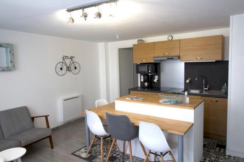 a kitchen and living room with a table and chairs at Cosy Apartment In The Center Of La Flotte in La Flotte