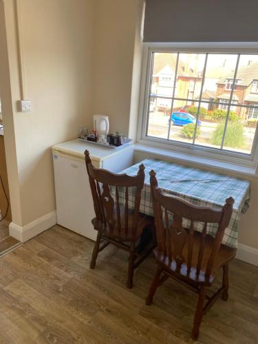 a kitchen with a table and two chairs and a window at Clarendon Lodge - accommodation only in Skegness