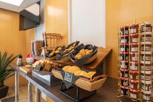 a bunch of baskets of bread on a table at Hotel Cerise Chatou in Chatou