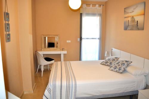 a bedroom with a bed with a chair and a desk at Marina Raset, 3 dormitorios, centro, by Bookindenia in Denia
