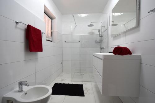 uma casa de banho branca com um lavatório e um WC em Apartments Petrovic em Malinska
