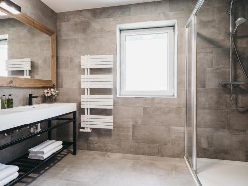 een badkamer met een douche en een wastafel bij VAYA Gerlos in Gerlos