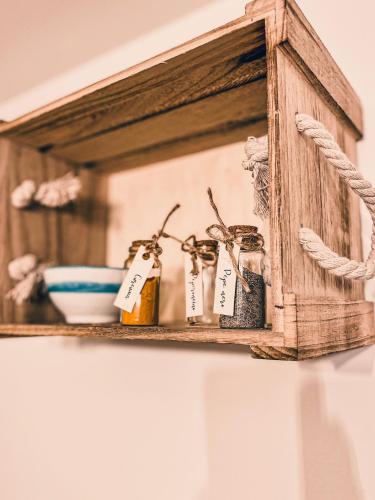 a wooden shelf with bottles of essential oils on it at Casa Perricci - short lets - Monopoli in Monopoli