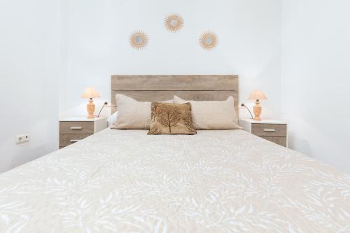 1 dormitorio blanco con 1 cama grande y 2 mesitas de noche en Home2Book Urban Gran Tarajal II, en Gran Tarajal