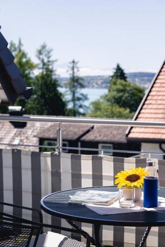 a table with a plate and a flower on a balcony at Kurviertel Wohnung II in Überlingen