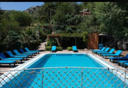 a swimming pool with blue lounge chairs next to it at Söğüt Butik Hotel in Marmaris