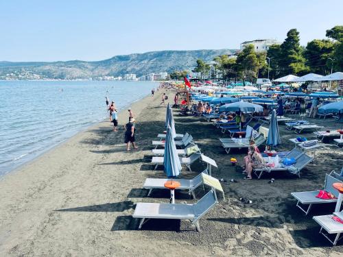 a beach with a bunch of chairs and umbrellas at Molla Hotel Restorant in Shëngjin