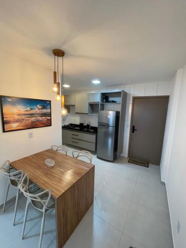 a kitchen and dining room with a wooden table and chairs at Apartamento em Jatiúca in Maceió