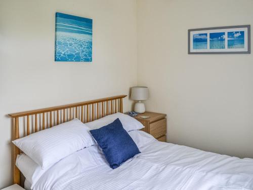 um quarto com uma cama com uma almofada azul em Seahorse Chalet em Humberston