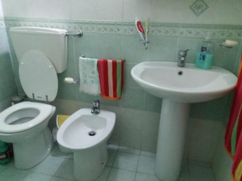 y baño con aseo y lavamanos. en Casa Vacanza a Punta Secca, en Punta Secca