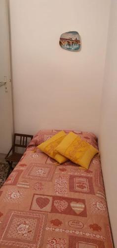 a bedroom with a bed with yellow pillows on it at Casa Vacanza a Punta Secca in Punta Secca