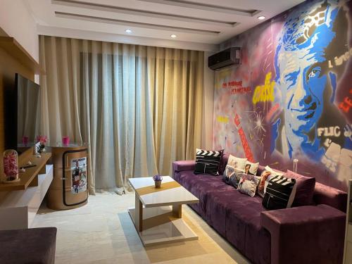 カサブランカにあるChez Bebelの紫色のソファと大きな壁画が備わるリビングルーム