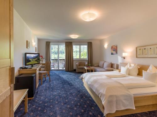 ホップフガルテン・イム・ブリクセンタールにあるLandhaus Margaretheの大型ベッドとテレビが備わるホテルルームです。
