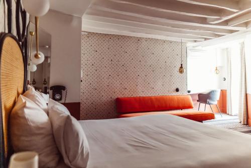 a bedroom with a bed and a couch and a window at Hotel Panache in Paris