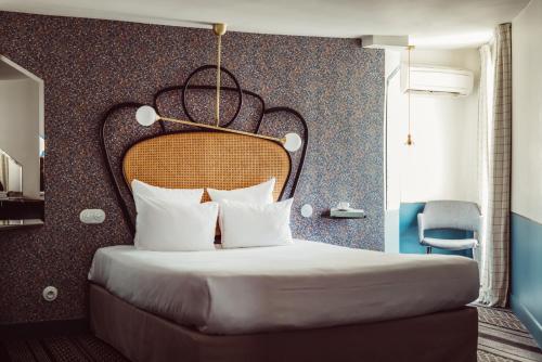 a bedroom with a large bed with a large headboard at Hotel Panache in Paris