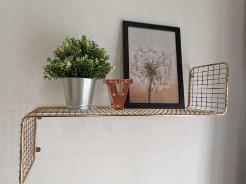 a shelf with a picture and a potted plant on it at Traders Garden in Cheras