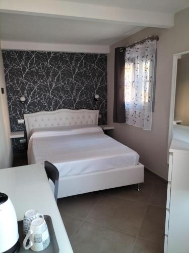 a bedroom with a white bed and a black and white wallpaper at LOCANDA LA SALITA in Monforte dʼAlba