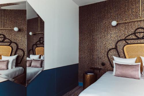 a bedroom with a bed and a mirror at Hotel Panache in Paris