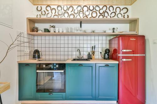 a kitchen with blue cabinets and a red refrigerator at Domki z Pasją in Kopalino